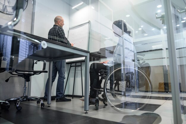 Behinderte junge Frau im Büro niedrige Ansicht