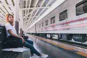 Kostenloses Foto beiläufige junge frau auf bahnhof