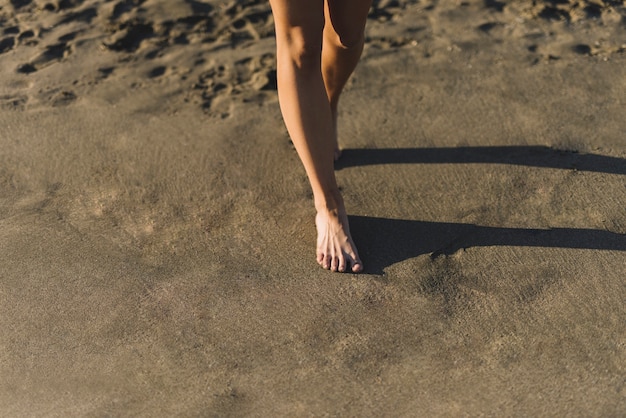 Kostenloses Foto bein blick auf frau zu fuß auf sand