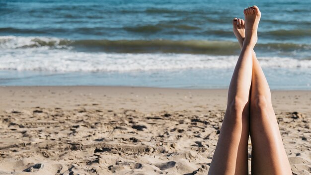 Beine der Frau am Strand