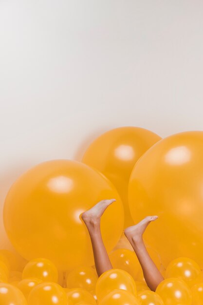 Beine der Frau zwischen vielen gelben Ballonen