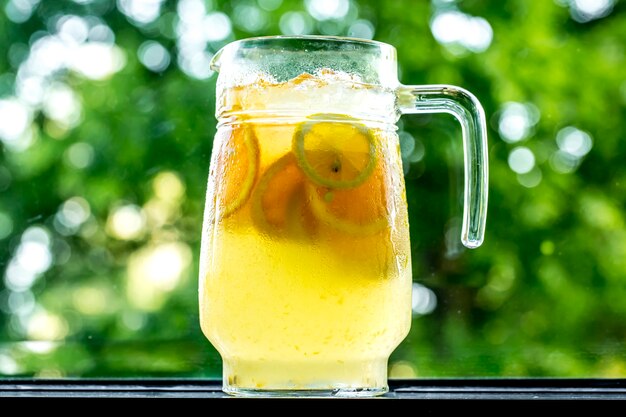 Belebende Limonade der Vorderansicht im Dekanter mit Zitrone und Orange