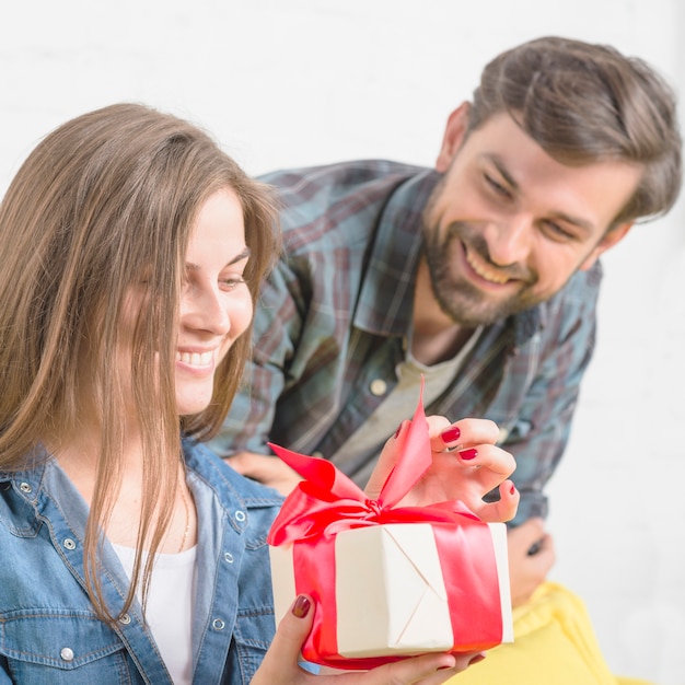 Bemannen Sie das Betrachten seiner Freundin, Valentinsgrußgeschenk auspackend