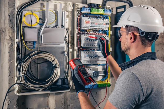 Bemannen sie einen elektrotechniker, der in einer schalttafel mit sicherungen arbeitet