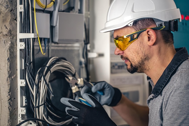 Bemannen Sie einen Elektrotechniker, der in einer Schalttafel mit Sicherungen arbeitet