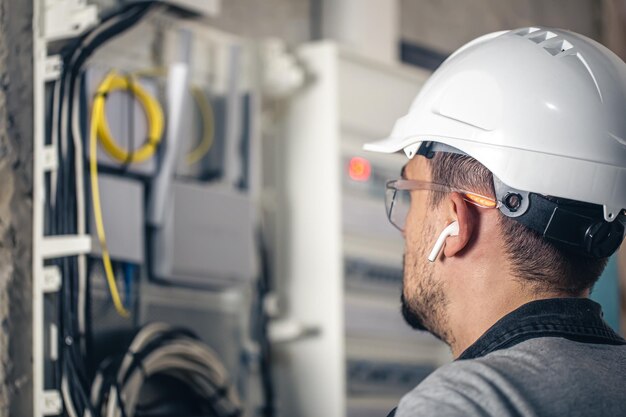 Bemannen Sie einen Elektrotechniker, der in einer Schalttafel mit Sicherungen arbeitet