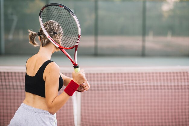 Üben des weiblichen Tennisspielers der Seitenansicht