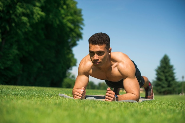 Übender Sport des athletischen Mannes im Freien