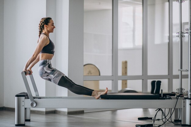 Übendes pilates der Frau in einem pilates Reformer