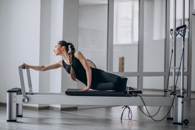 Übendes pilates der Frau in einem pilates Reformer