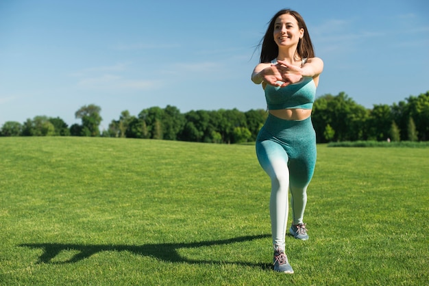 Übendes Yoga der athletischen Frau im Freien