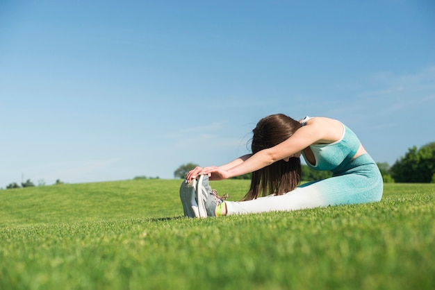 Übendes Yoga der athletischen Frau im Freien