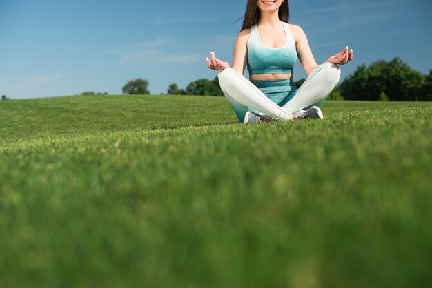 Übendes Yoga der athletischen Frau im Freien