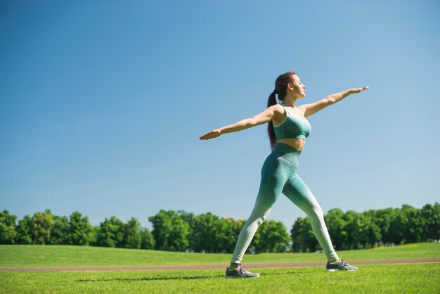 Übendes Yoga der athletischen Frau im Freien