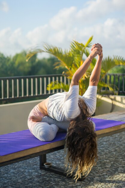 Übendes Yoga der jungen Frau