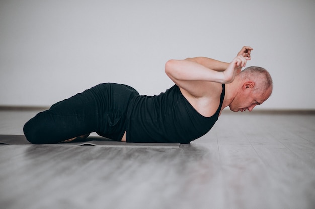 Übendes Yoga des Mannes in der Turnhalle