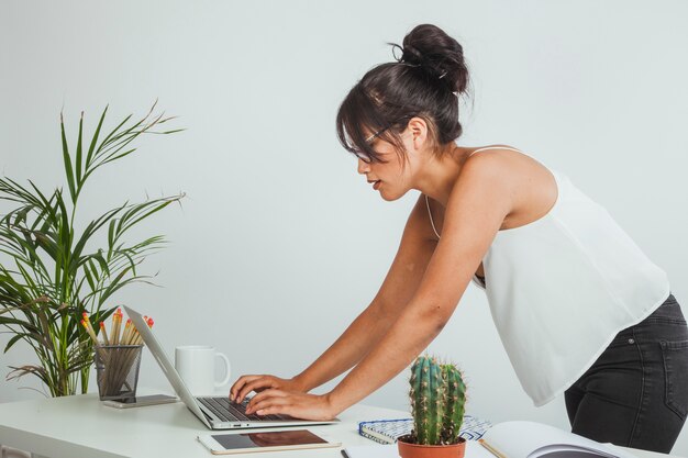 Bent Frau Eingabe auf dem Laptop