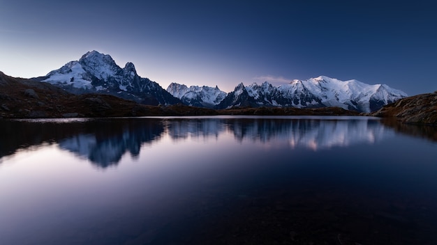 Berg Mont Blanc bedeckt im Schnee, der am Abend in Chamonix, Frankreich über das Wasser reflektiert