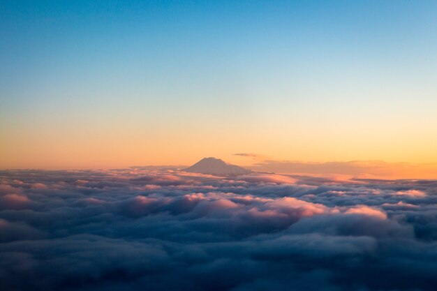 Berg über weißen Wolken während des Tages