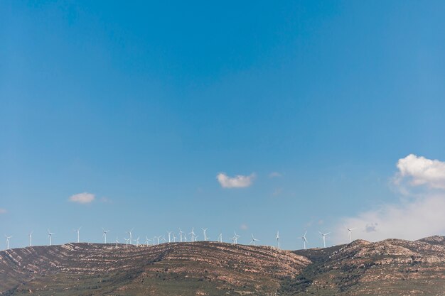 Berge mit Windmühlen unter blauem Himmel