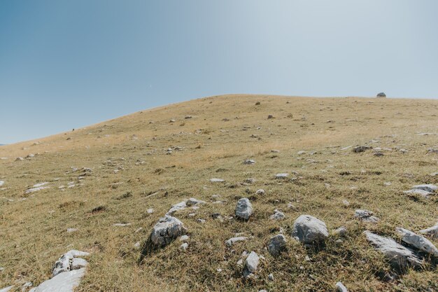 Berge und Hügel mit vielen Felsen unter dem schönen blauen Himmel