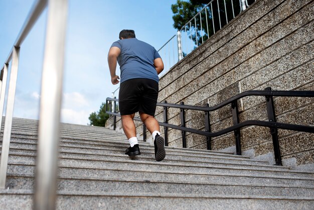 Übergewichtiger Mann, der draußen auf Treppen trainiert
