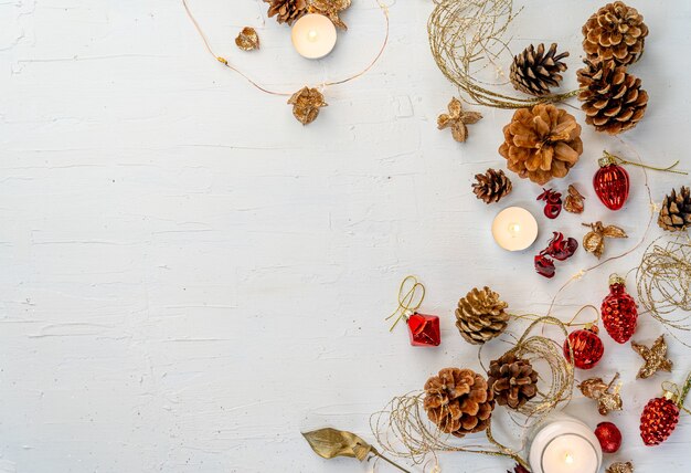 Überkopfaufnahme eines rustikalen bunten Weihnachtsdekors auf weißem Holztisch mit Platz für Ihren Text