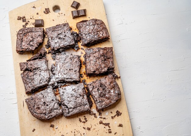 Überkopfaufnahme von frisch gebackenen Brownies auf einem Holzbrett