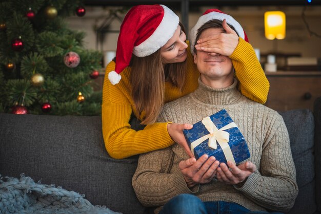 Überraschender Mann der mittleren Schussfrau mit Geschenk