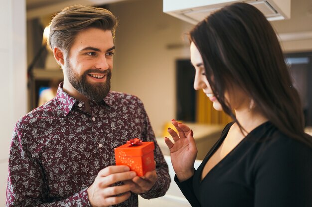 Überraschte Frau, die Geschenk vom Freund hat