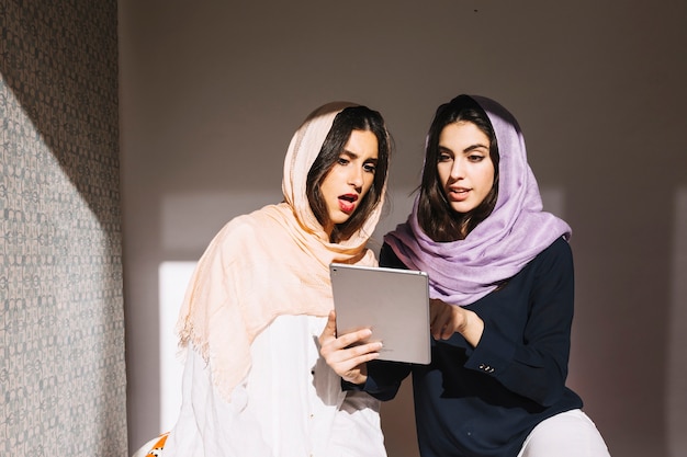 Überraschte moslemische Frauen mit Tablette