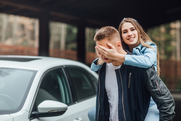 Überraschung für Ehemann, Frau nahe weißem Auto