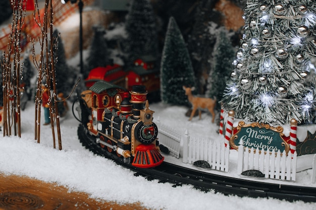 Berühmtes neujahrs- und weihnachtsspielzeug von lemax-dekorationen mit weihnachtsbaum, schnee und zug. luxuriöse geschenke und dekorationen für die winterferien