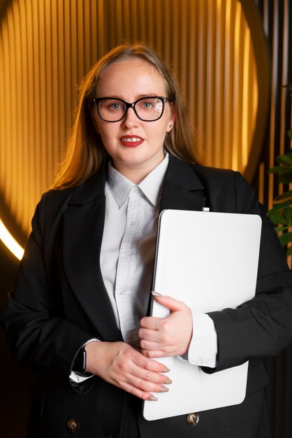 Berufstätige Frau im stilvollen Anzug im Büro mit Laptop