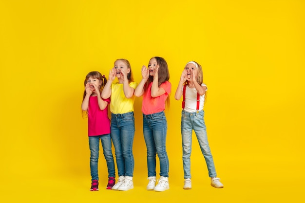 Berufung. Glückliche Kinder, die zusammen an der gelben Studiowand spielen und Spaß haben.