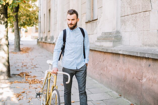 Überzeugter Mann, der mit Fahrrad geht