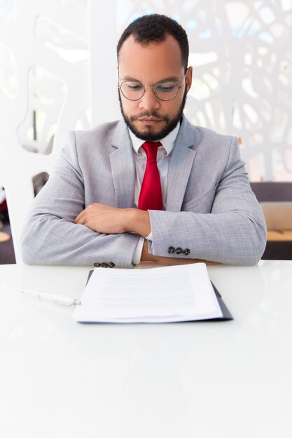 Überzeugter Unternehmensleiter, der Vertrag studiert