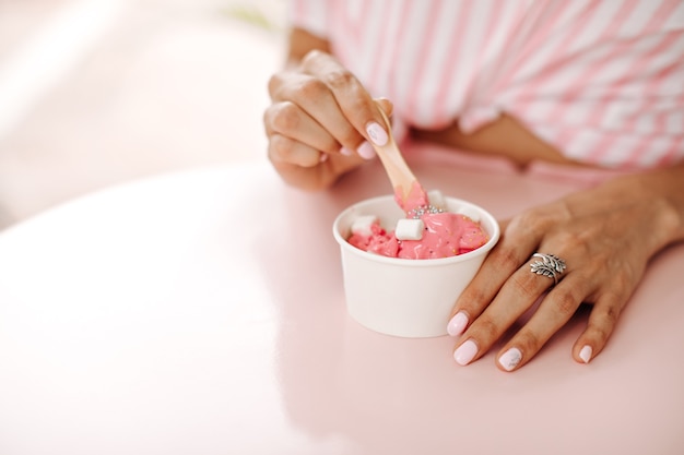 Beschnittene Ansicht der Frau mit Ring, die Eis isst. Selektiver Fokus der Frau, die leckeres Dessert genießt.