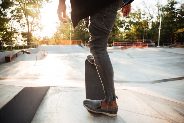 Beschnittenes bild eines jungen männlichen teenagers, der ein skateboard reitet