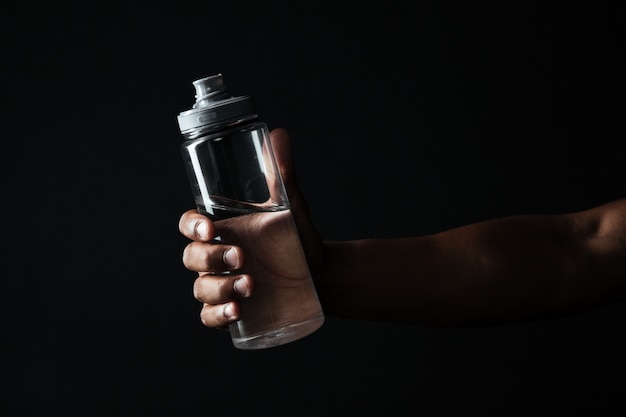 Beschnittenes Foto der Hand der afroamerikanischen männlichen Hand, die Flasche mit Wasser hält