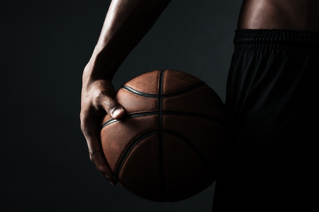 Beschnittenes Foto des Basketballspielers, der Ball hält