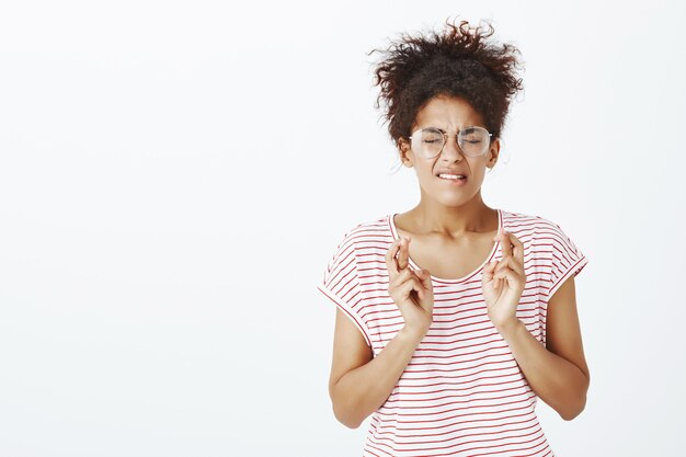 Besorgte Frau mit Afro-Frisur, die im Studio aufwirft