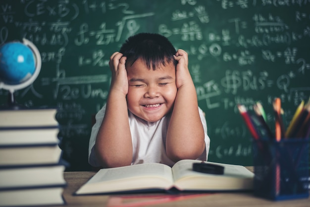 besorgter Junge im Klassenzimmer mit den Händen auf Kopf