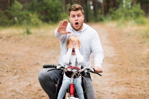 Besorgter Vater und Tochter der Vorderansicht auf Fahrrad