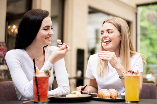 Beste Freunde, die an einem Restaurant essen