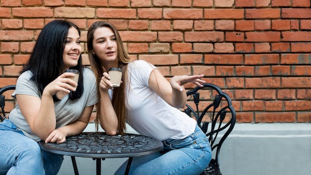 Beste Freunde, die ihren Kaffee zusammen mit Kopierraum nehmen