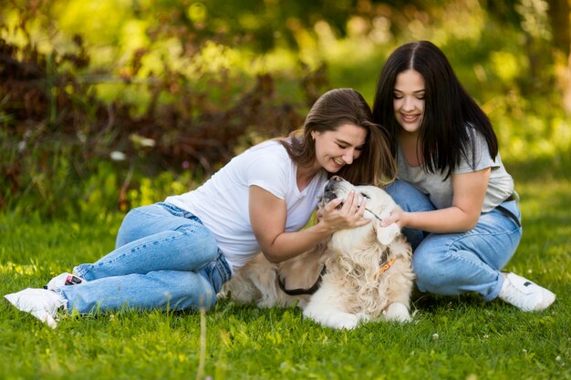 Beste Freunde, die mit einem Hund spielen