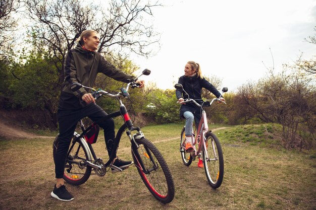 Beste Freunde, die Spaß in der Nähe des Landschaftsparks haben, sich nach dem Fahrradfahren ausruhen, Zeit miteinander verbringen?