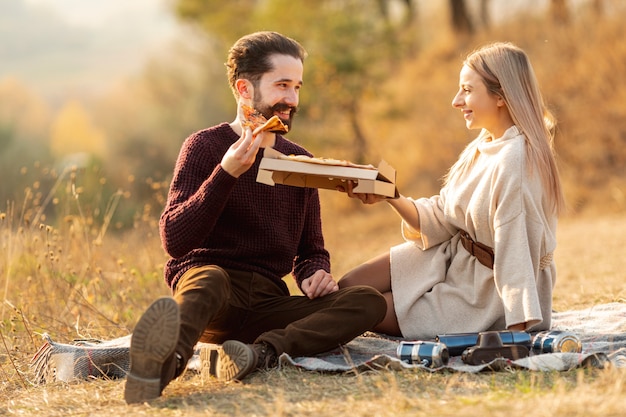 Beste Freunde, die zusammen eine Pizza draußen genießen