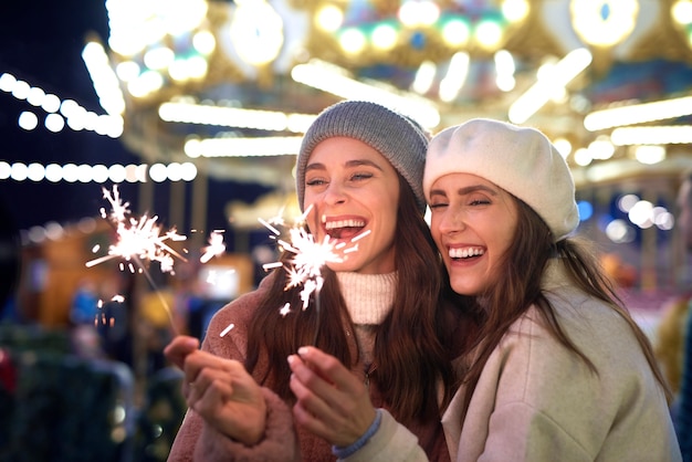 Beste Freunde mit Wunderkerzen auf dem Weihnachtsmarkt